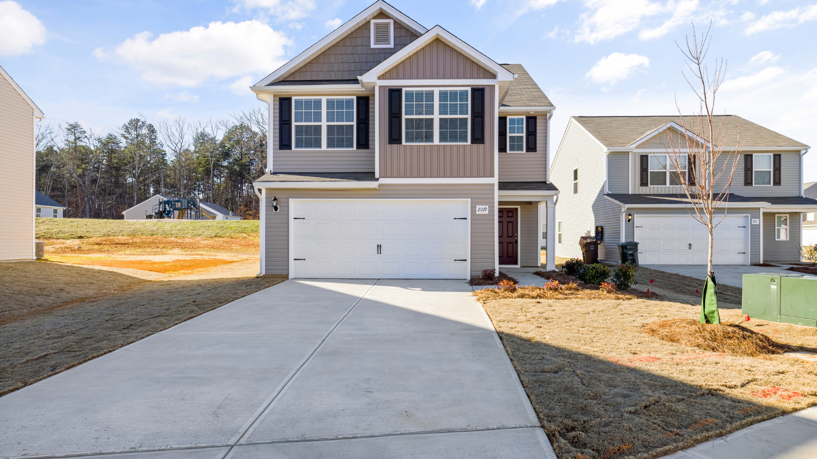 A two story house with a driveway in front of it