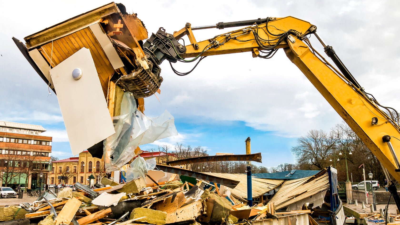 A large yellow construction machine moving a pile of rubble