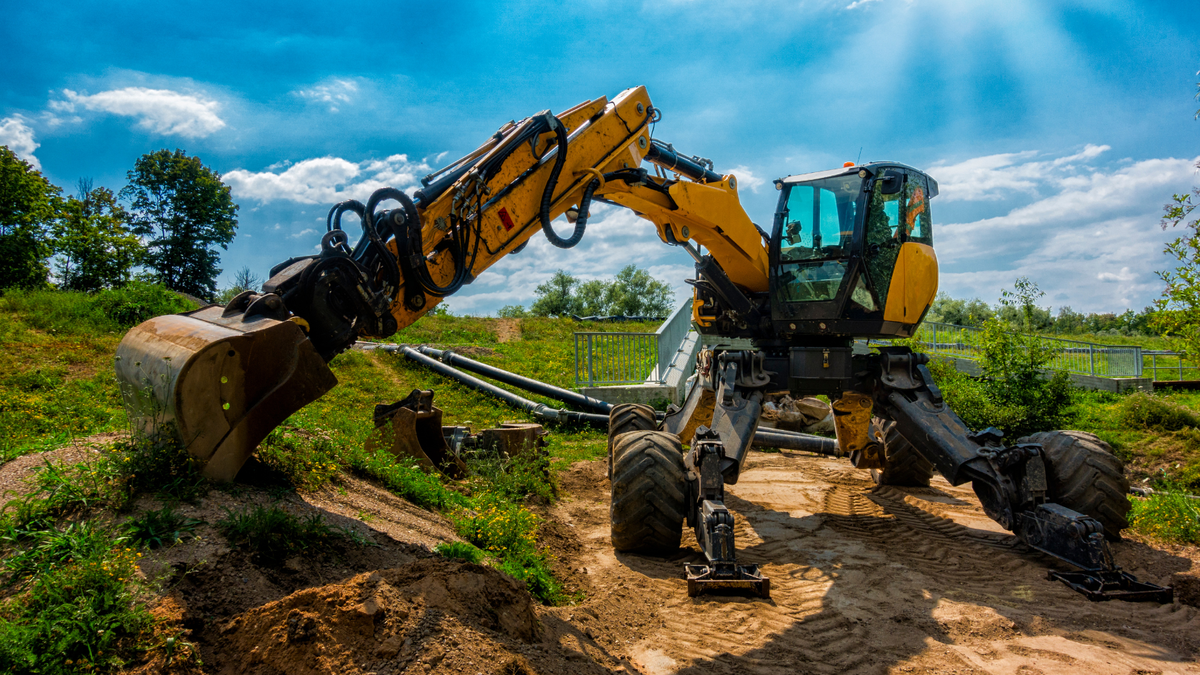 A yellow and black construction vehicle on a dirt road